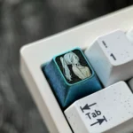 Multiple views of the Frieren titanium keycap, showcasing its ethereal ice crystal blue finish and premium titanium alloy craftsmanship from various design.