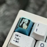 A gallery of Frieren Titanium Keycaps, spotlighting the premium titanium alloy and ethereal ice crystal blue. Various angles emphasize its characteristic.
