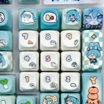 A vibrant gallery showcasing the exclusive Hatsune Miku mechanical keycap set from multiple angles, featuring playful character art and musical