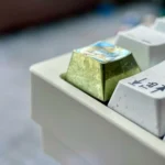 Aerospace Aiz Wallenstein Keycap, anodized orange. Gallery displays unique industrial-artistic design, sleek metallic form, and premium quality form.