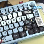 Playful gallery of vibrant Akiyama Mio PBT pudding keycaps set, showcasing K-On! character art and translucent RGB sides from multiple angles.