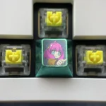 Vibrant Anya Forger titanium alloy keycap set displayed, showcasing iconic Spy x Family anime expressions on lustrous metal, a truly artistic upgrade.