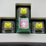Artistic display of the vibrant Anya Forger titanium alloy keycap set, highlighting her iconic anime expressions on each lustrous key.