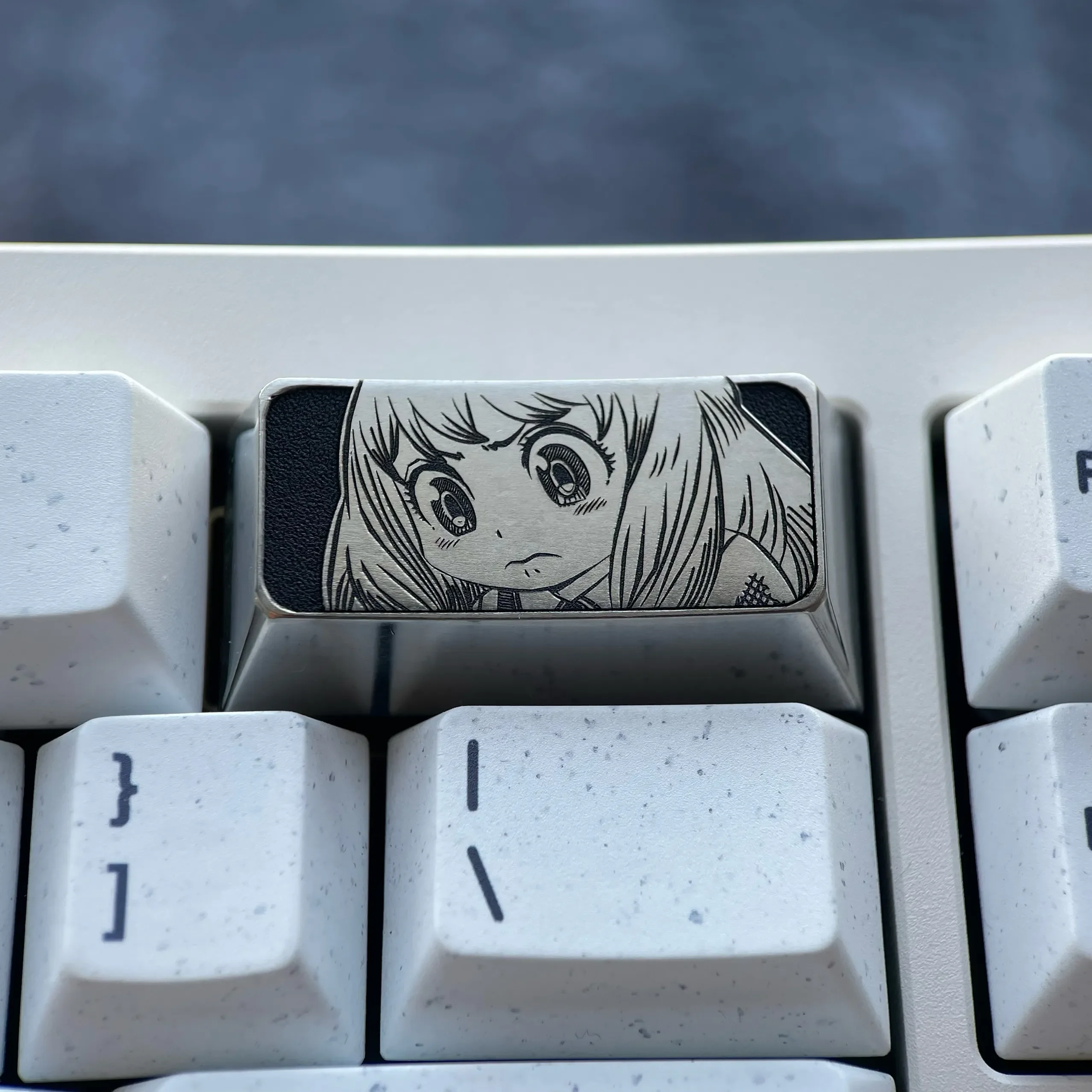 Anya Titanium Keycap gallery reveals the premium engraved 2U backspace with iconic Anya Forger design and sophisticated dark grey metallic finish.
