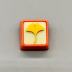 Close-up of a handcrafted artisan leaf keycap, showcasing delicate green leaves beautifully suspended in clear resin, evoking natures calm.