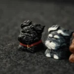 Whimsical black puppy artisan keycap handcrafted from resin, showcased from various angles to highlight its unique detail for mechanical keyboards.
