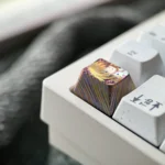 Multiple views of the artisan Asuka Langley Soryu titanium keycap, highlighting its vibrant hand-carved Evangelion details and luxurious metallic design.