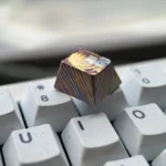 Multiple angles of the exquisite hand-carved titanium Asuka Evangelion keycap, showcasing its vibrant details and premium metallic finish.