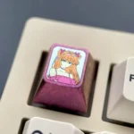 Premium pink anodized titanium Asuka ESC keycap featuring iconic character art, a vibrant and bold centerpiece for mechanical keyboards.