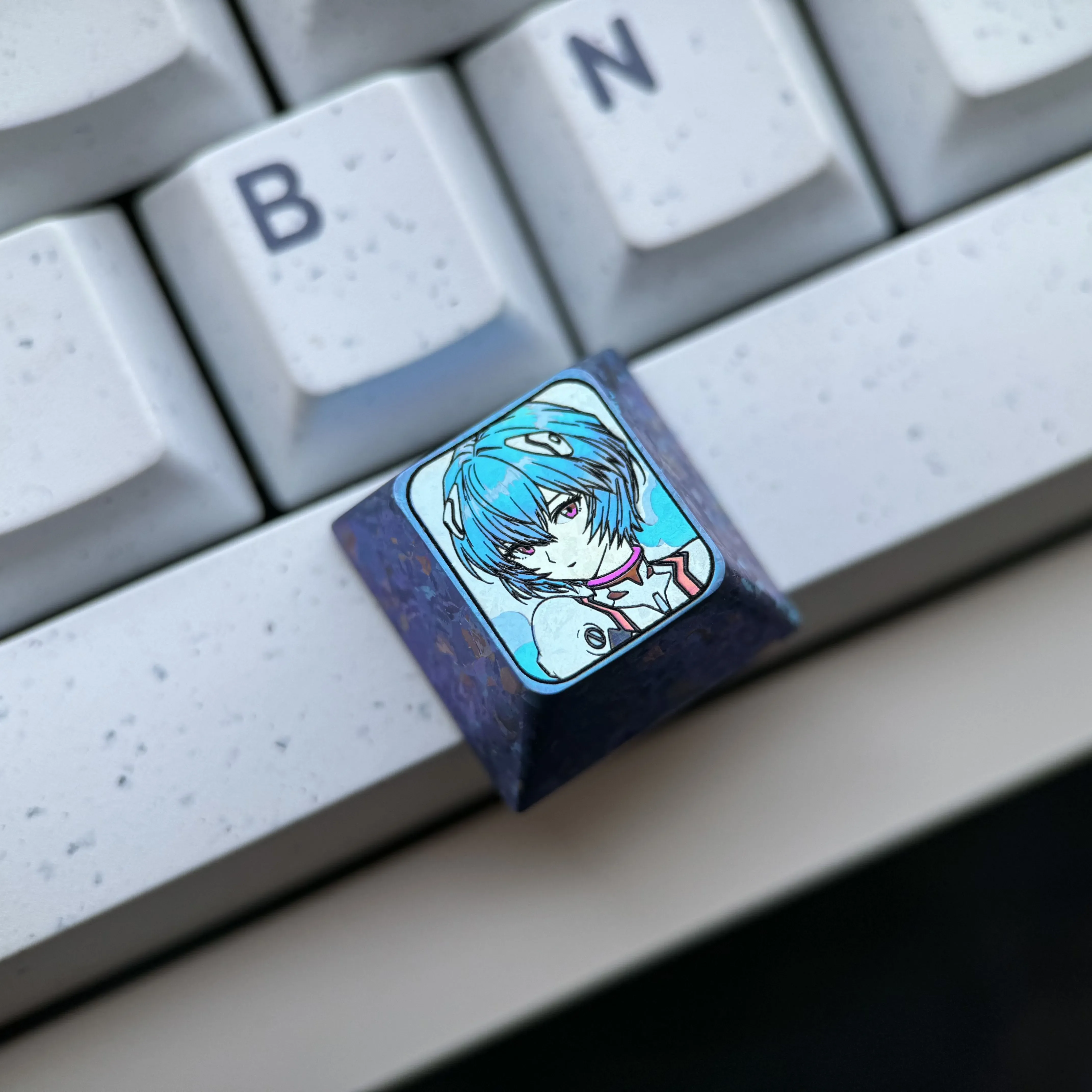 Close-up views of the exquisite Titanium Rei Ayanami keycap, showcasing its icy crystal blue design and intricate EVA tribute artwork.