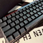 Sleek forged black carbon fiber side-print keycap set for mechanical keyboards, featuring a premium matte finish and sophisticated texture.