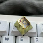 Close-up views of the Premium Ereshkigal Keycap reveal intricate anime design, vibrant iridescent colors, and luxurious titanium alloy construction.