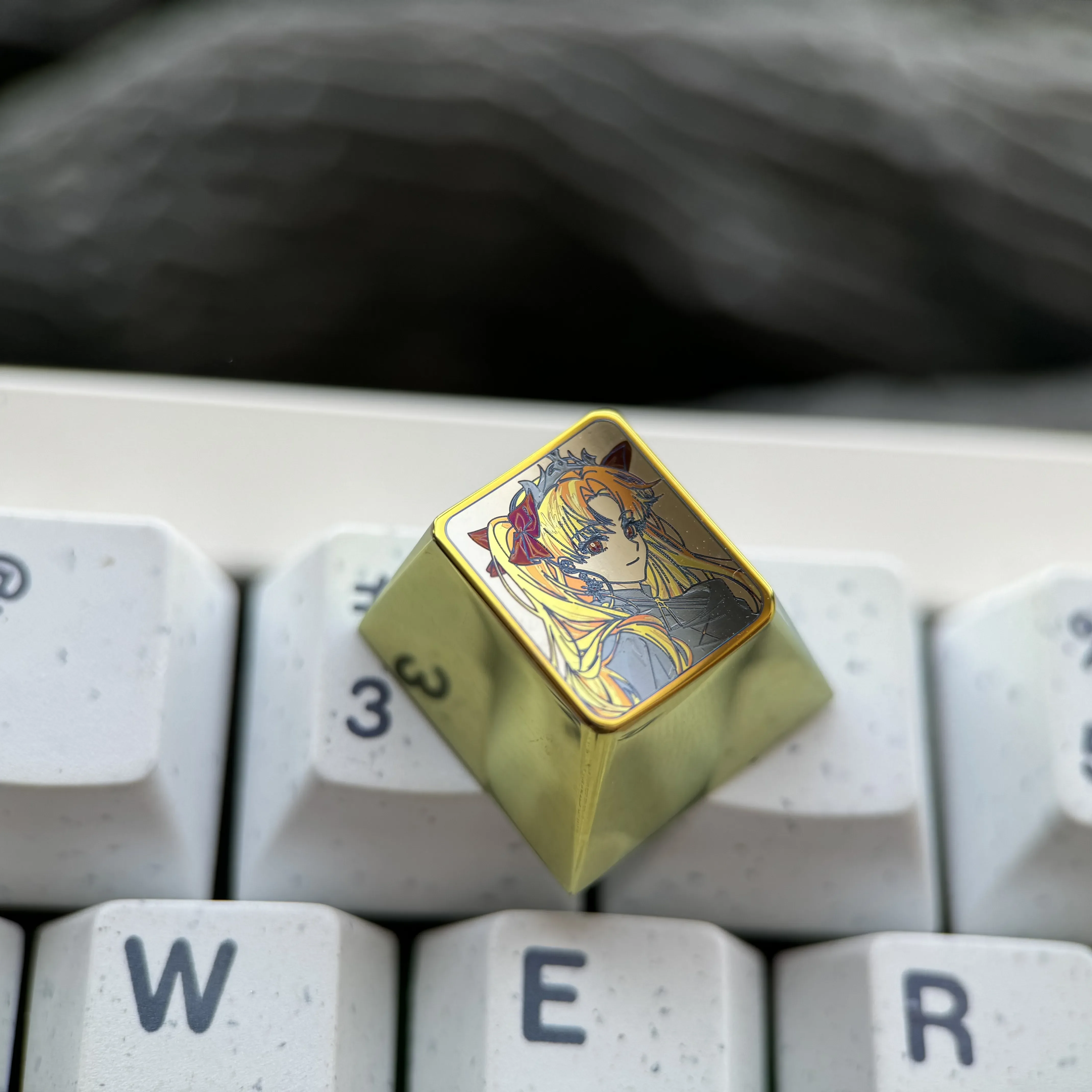 Close-up views of the Premium Ereshkigal Keycap reveal intricate anime design, vibrant iridescent colors, and luxurious titanium alloy construction.