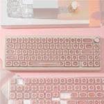 Ethereal pink keycap set are meticulously displayed from multiple angles, revealing their luminous PBT cat's eye effect and mystical gemstone.