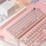 Ethereal Pink Keycap Set displayed from various angles, revealing their luminous PBT cat's eye effect and shifting gemstone-like luminescence.