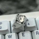 Hand-sculpted Frieren keycap in mirror-finish titanium, showcasing a precision-carved Frieren portrait with intricate stippling.