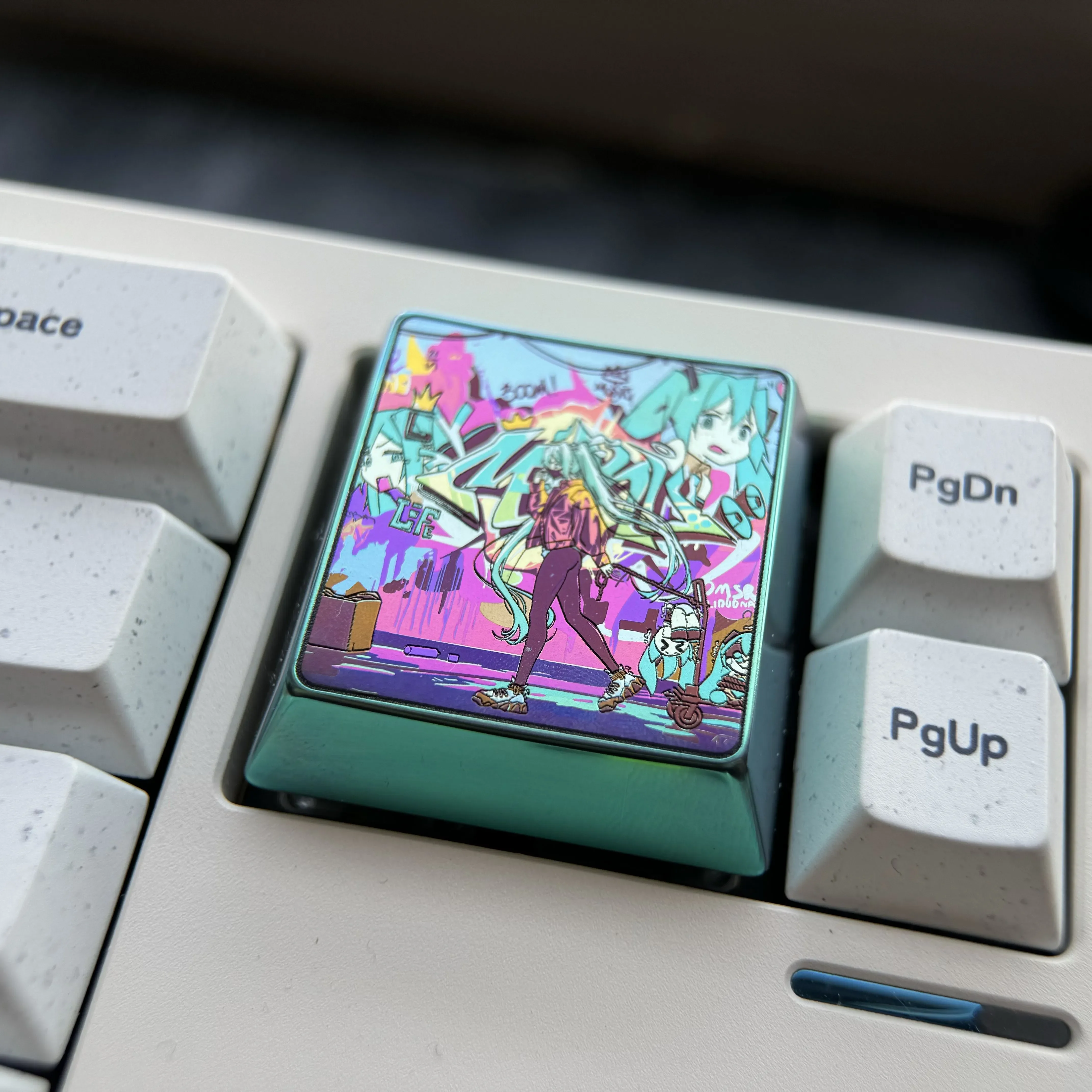 A collection of artistic shots showcasing the iconic Hatsune Miku titanium alloy keycap, highlighting its vibrant art and iridescent futuristic design.