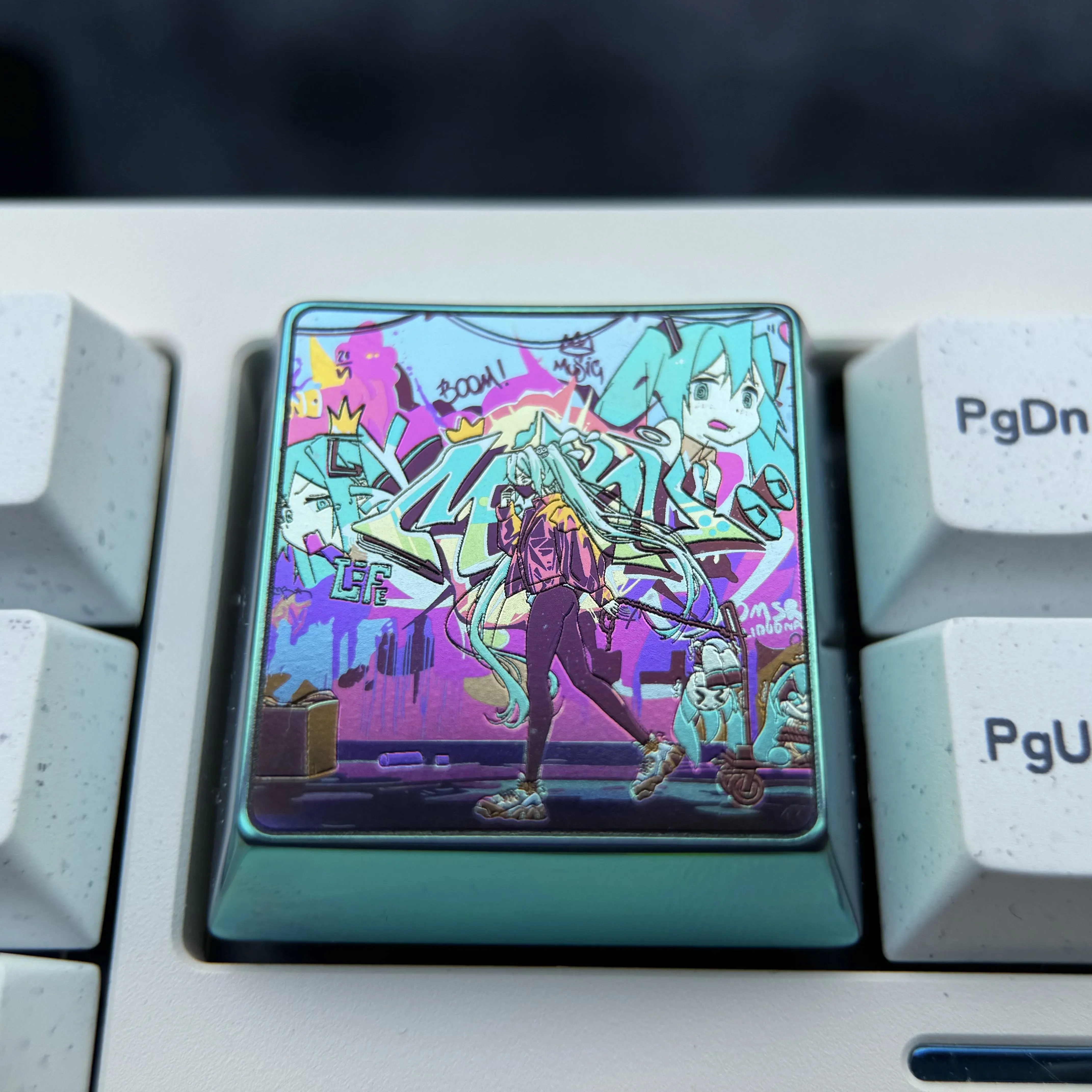 Vibrant Hatsune Miku keycap made from premium titanium alloy, showcasing iridescent art and a futuristic design for keyboards.