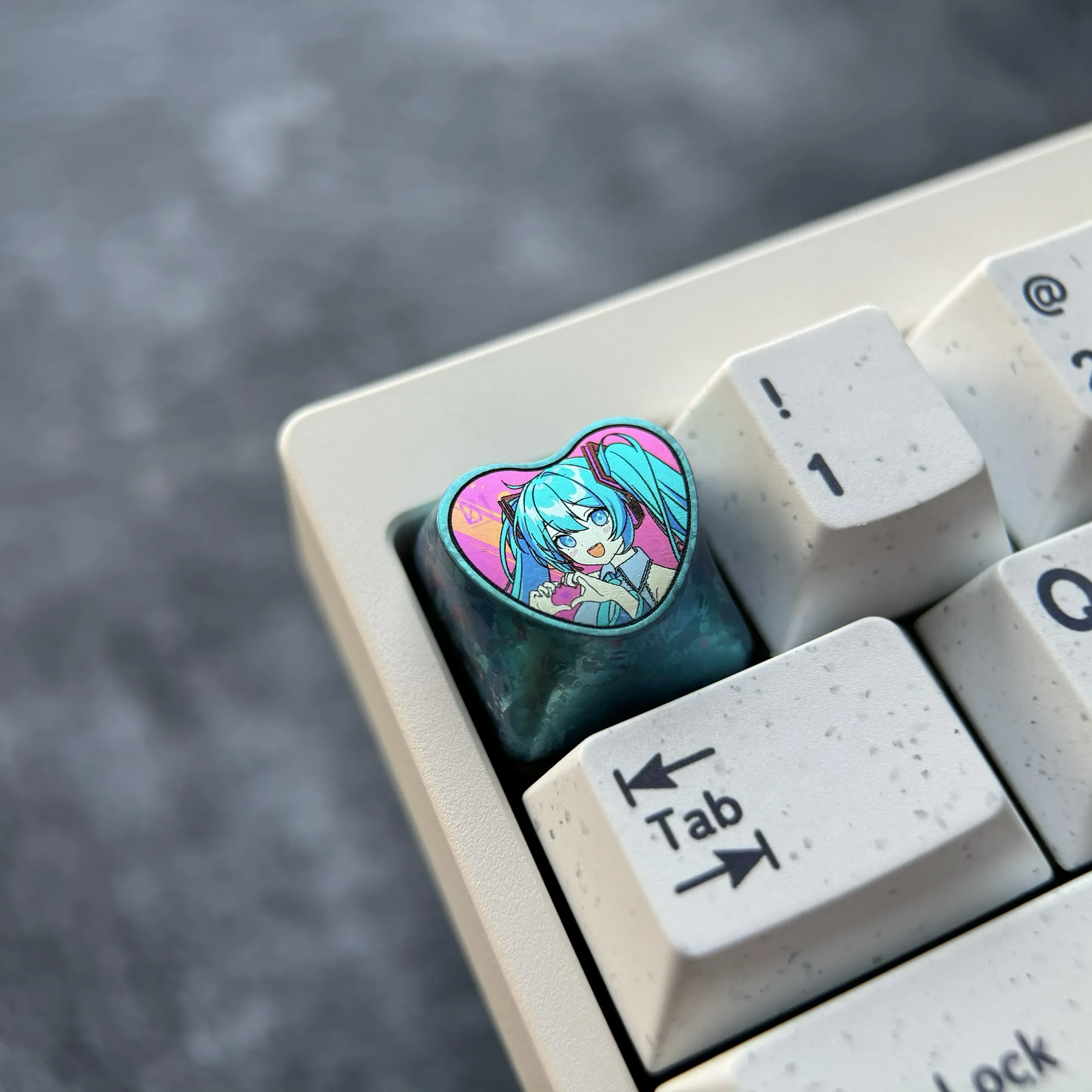 Official Hatsune Miku Titanium Artisan Keycap gallery shows vibrant heart design, polished colorful metal from various angles.