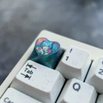 Official Hatsune Miku titanium artisan keycap gallery. Vibrant heart design on polished, colorful metal, showcased from diverse artistic angles.