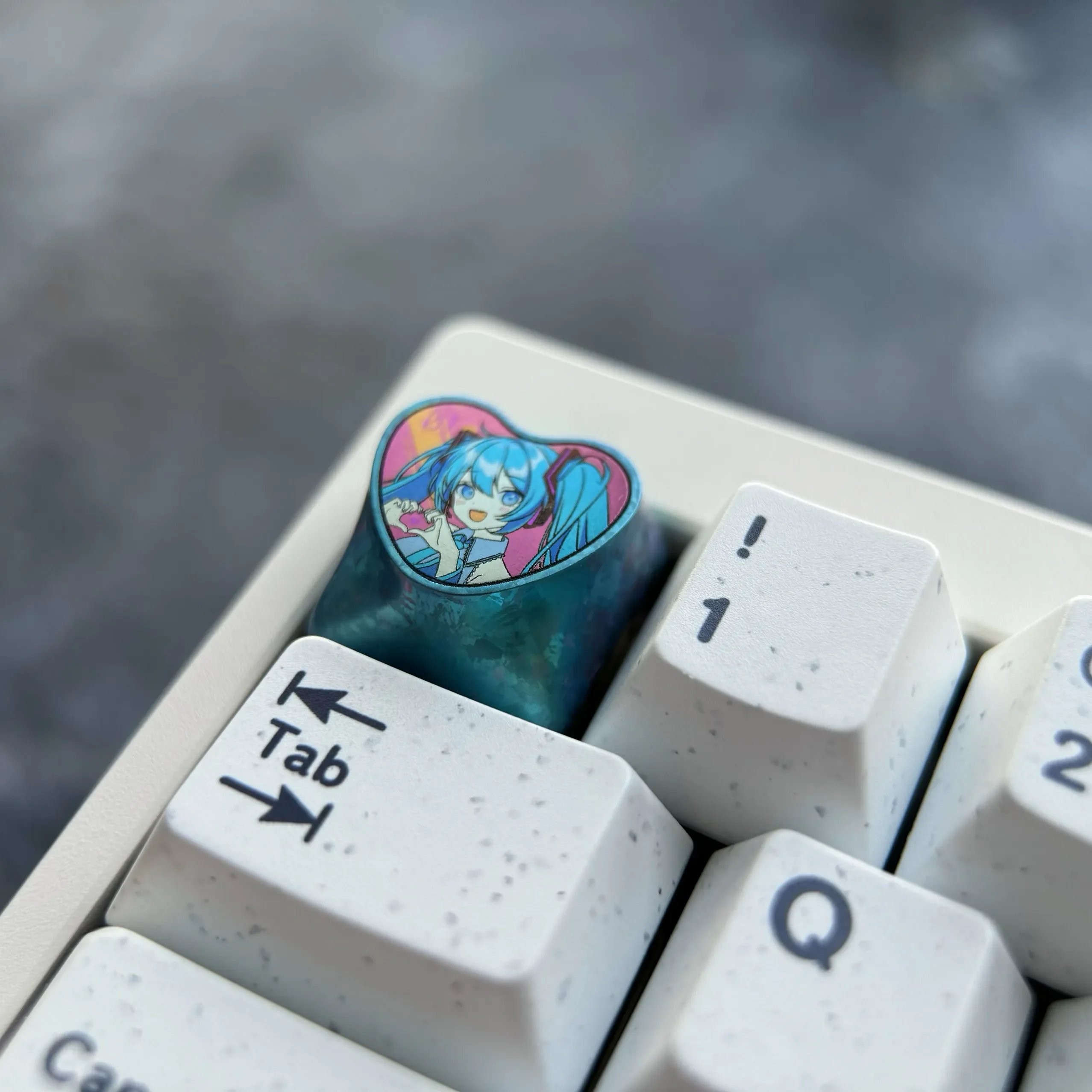 Official Hatsune Miku titanium artisan keycap gallery. Vibrant heart design on polished, colorful metal, showcased from diverse artistic angles.