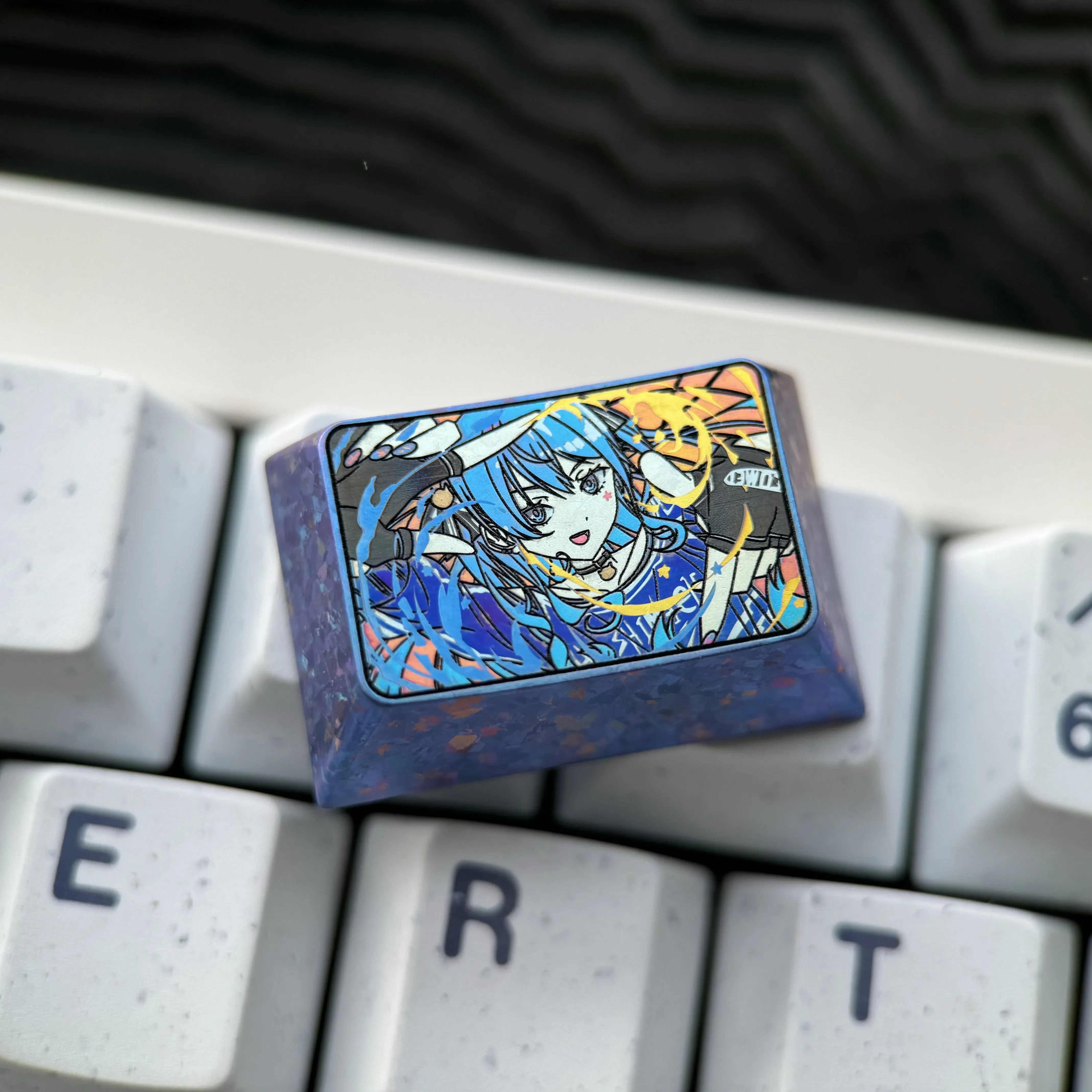 Various views of the premium Hoshimachi Suisei titanium keycap, highlighting its intricate ice crystal VTuber art and radiant finish.