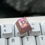 Multiple angles of the exclusive Ichinose Honami titanium keycap, highlighting the vibrant anime art on its lustrous metallic canvas for mechanical keyboard.