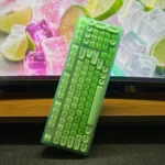 Vibrant lime green 98-key tri-mode mechanical keyboard, angled to showcase hot-swappable switches and wireless connectivity on a modern desktop.