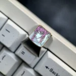 A gallery view of the premium hand-carved Makima titanium keycap, highlighting the intricate line art and sleek alloy from various perspectives.