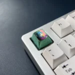 Multiple views of the premium titanium Maomao Keycap, showcasing its vibrant anime cat motif from The Apothecary Diaries with a polished metallic design.