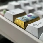 Vibrant Naruto and Sasuke titanium artisan keycaps displayed from multiple angles, showcasing intricate anime detailing and premium alloy design.