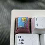 Close-up of the premium titanium ONE PIECE artisan keycap, highlighting its iconic vibrant anime design and intricate metal craftsmanship.