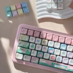 Raspberry Ice Whimsy PBT Dye-Sub Keycap Set. Showcases premium PBT, unique pastel pink, creamy white dessert theme, and hand-drawn berry accents.