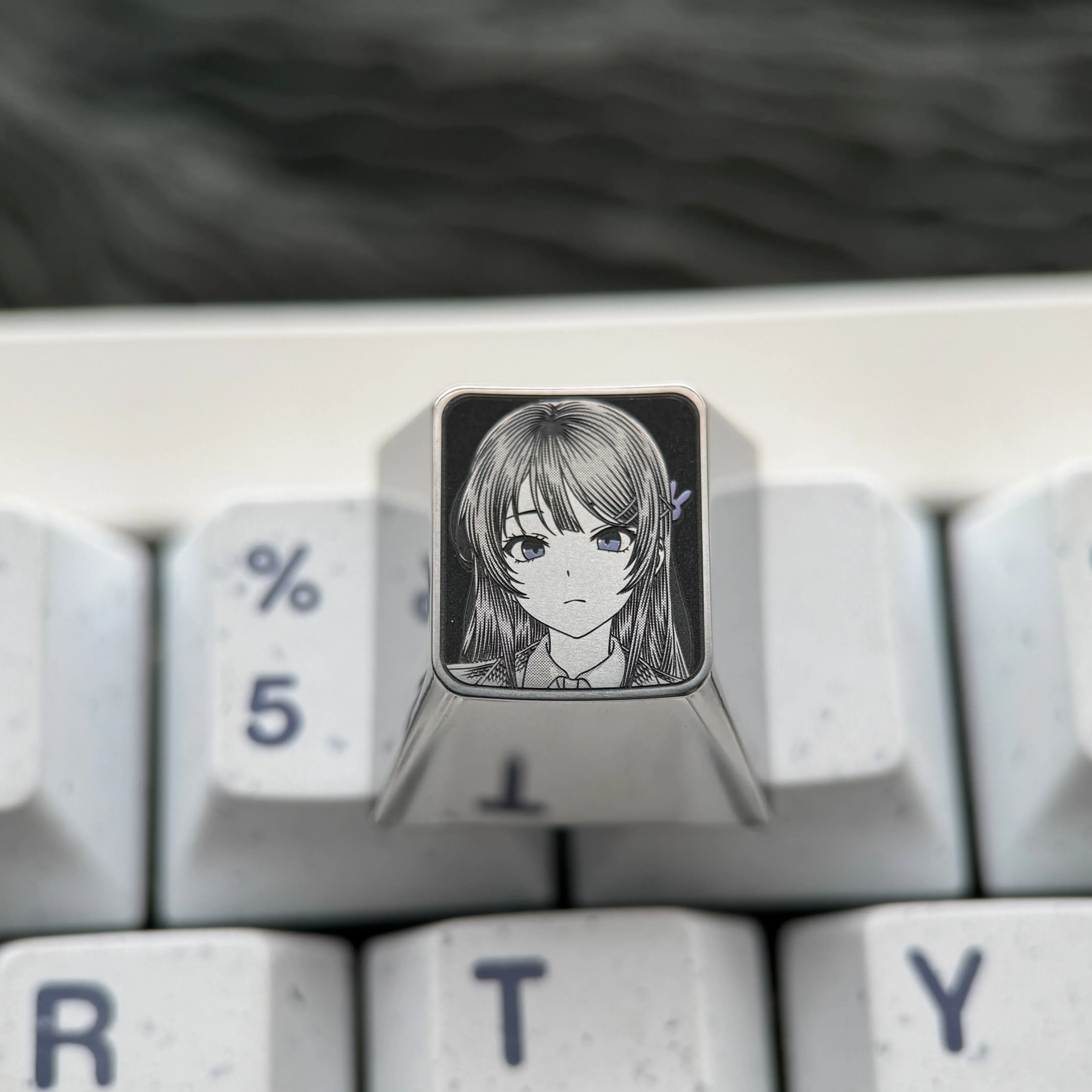 Premium Sakurajima Mai titanium keycap, meticulously engraved with anime art, exhibiting its exquisite metallic finish and artisan craftsmanship.