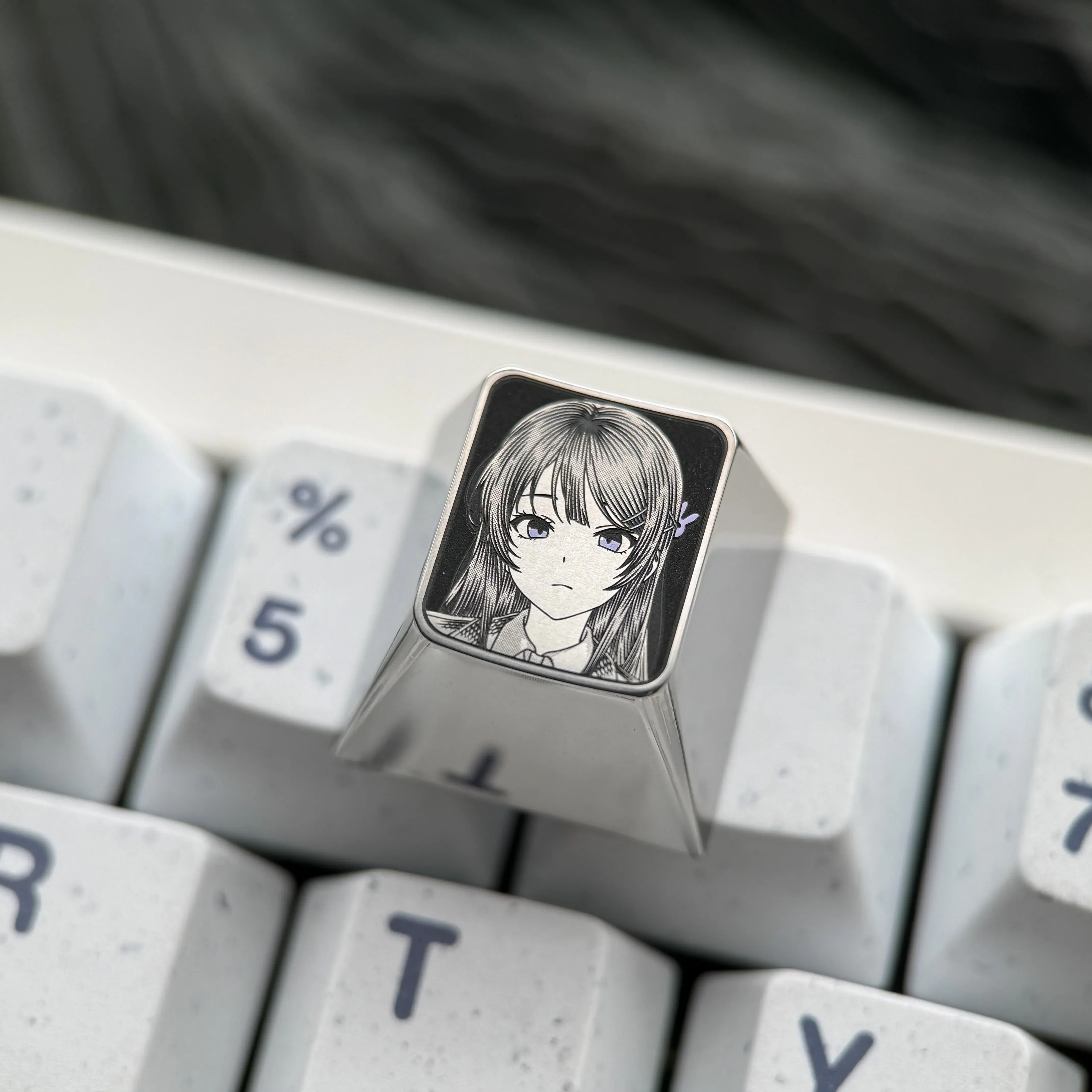 Premium Sakurajima Mai engraved titanium artisan keycap showcased from various angles, highlighting its intricate anime artwork and precise metallic.