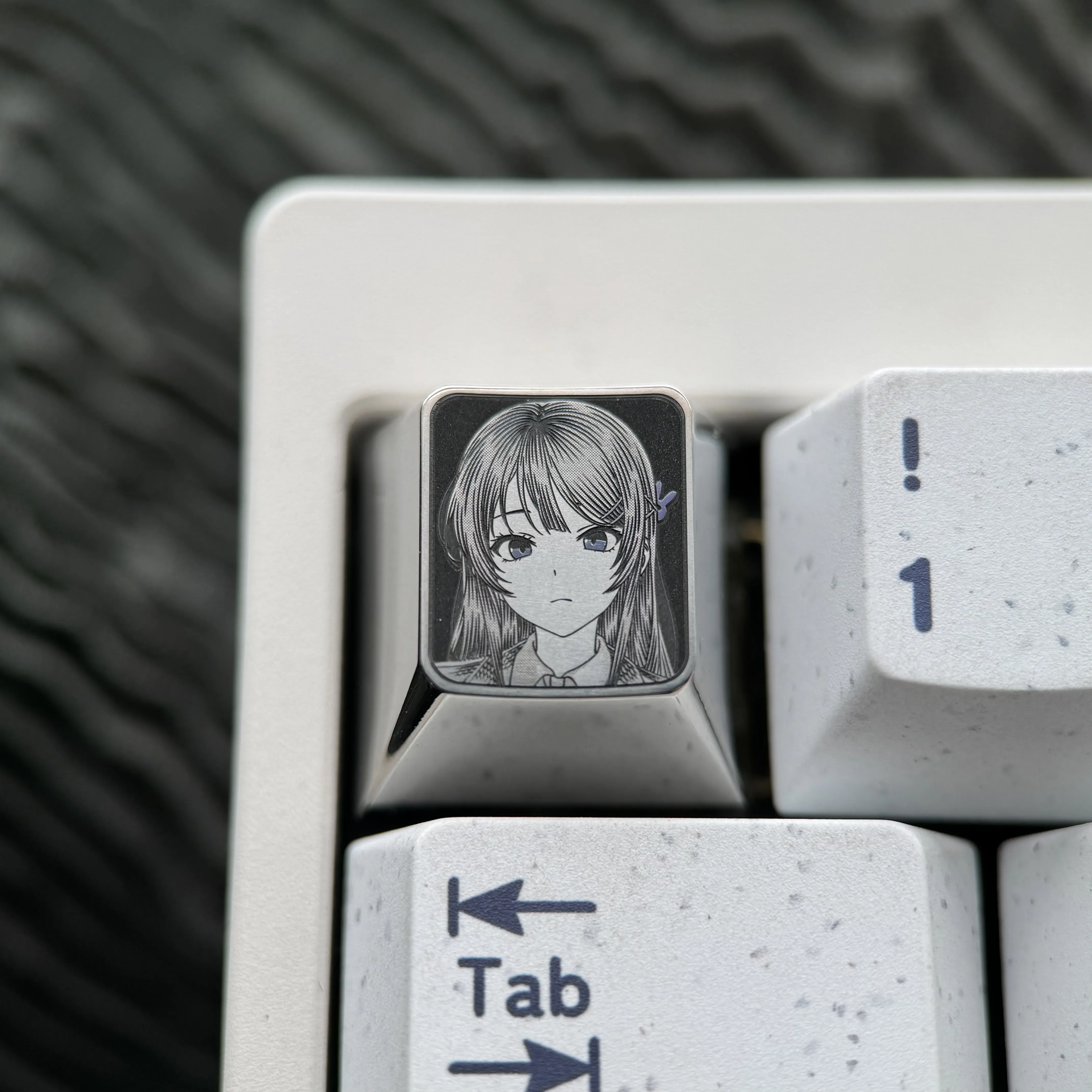 Detailed views of the premium Sakurajima Mai engraved titanium keycap, showcasing its intricate anime art and lustrous metallic finish.