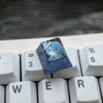 Detailed views of The Shorekeeper Titanium Keycap, a premium artisan ESC key for custom mechanical keyboards with intricate design.