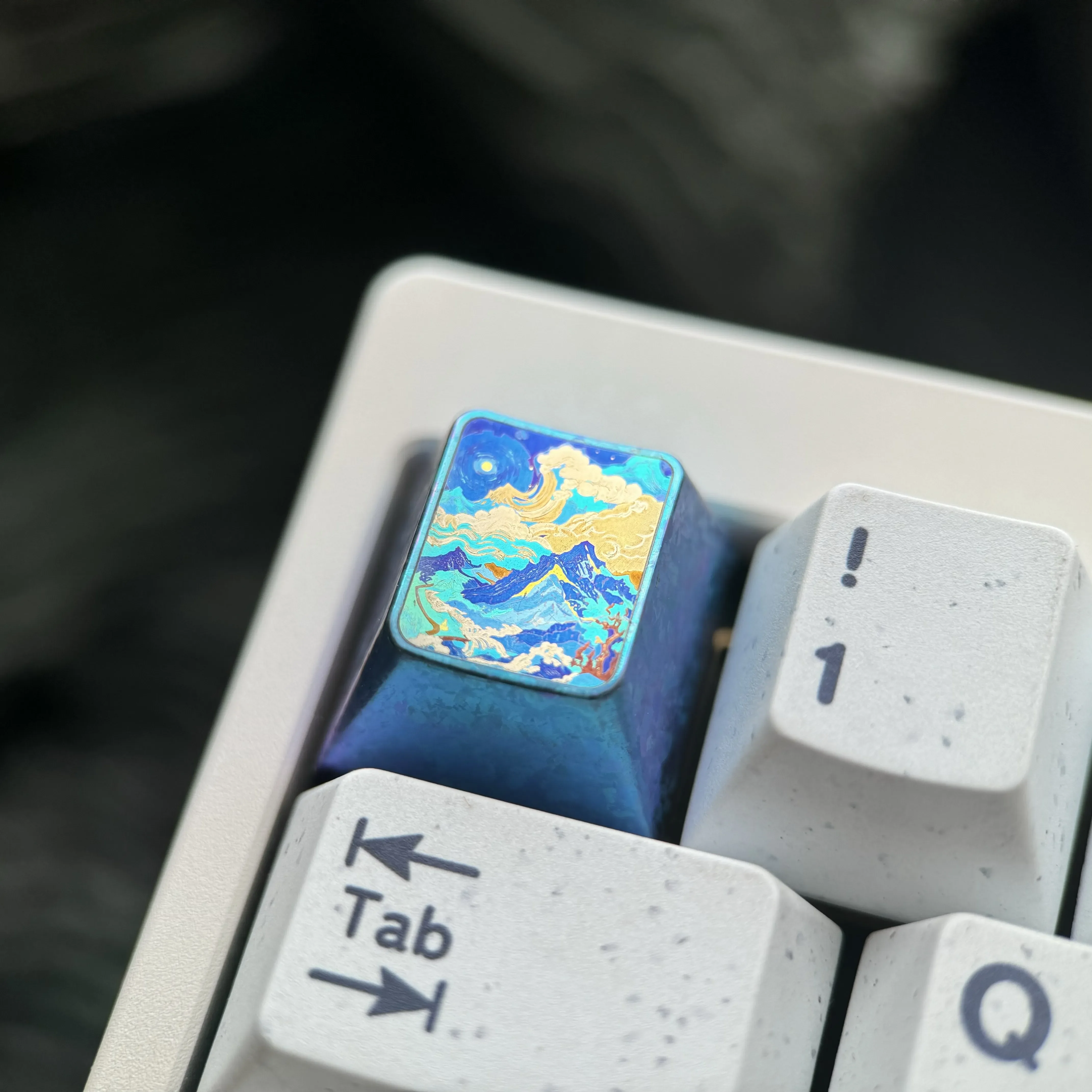 Showcasing the handcrafted titanium alloy mountain artisan keycap from multiple views, revealing its abstract design and durable, vibrant metallic design.