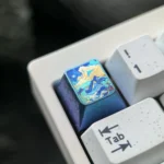 Gallery views of the handcrafted titanium alloy mountain artisan keycap, highlighting its vibrant metallic colors and abstract serene design.