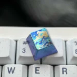 Handcrafted titanium artisan keycap, displayed from various angles, revealing its serene abstract mountain range and durable vibrant metallic finish.