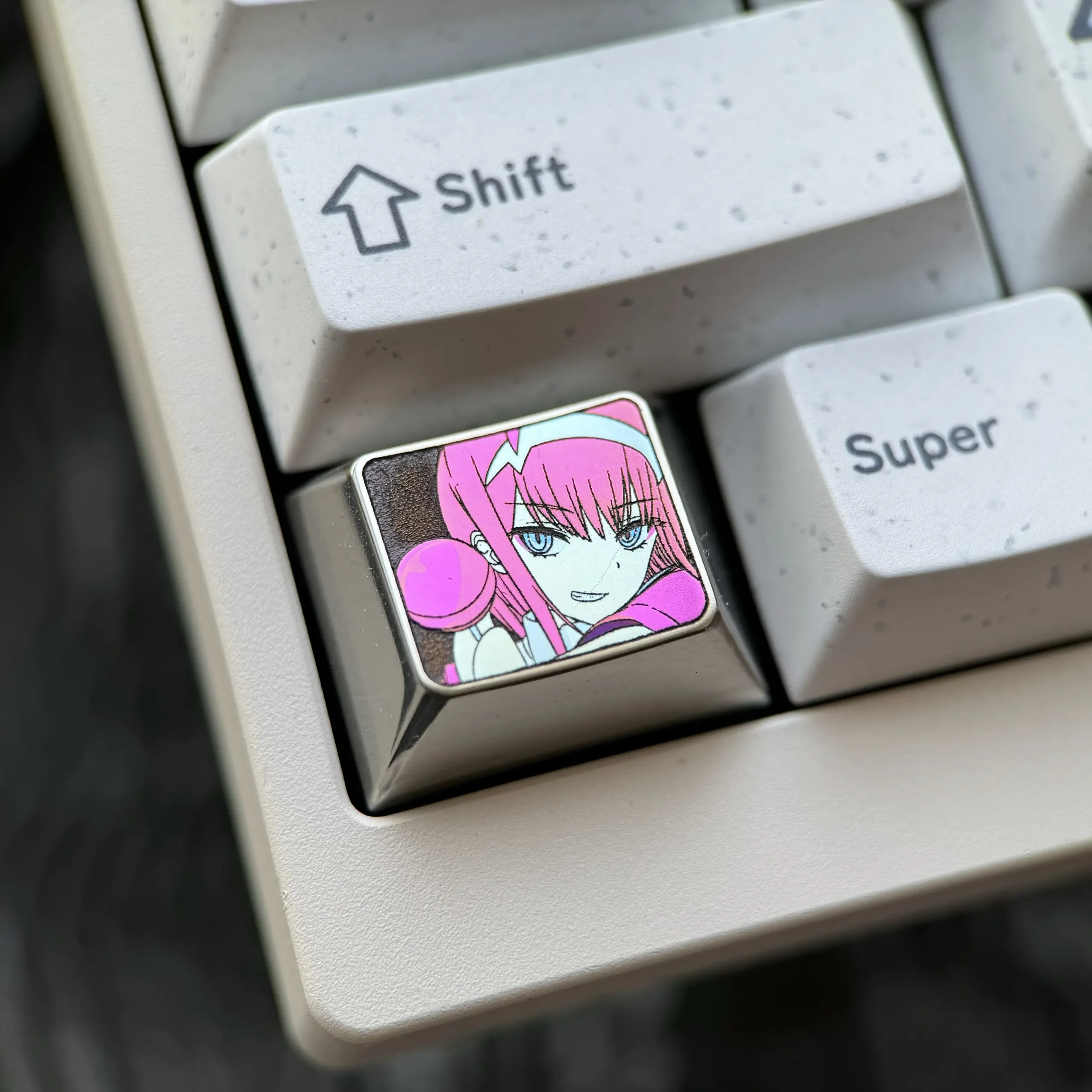 A striking Zero Two Titanium Keycap, showcasing its premium artisan craftsmanship and vibrant metallic finish for a truly personalized setup.