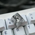 Artisan Violet Evergarden titanium keycap gallery, highlighting intricate hand-carved anime details and delicate lines on its lustrous finish.