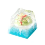 Whimsical handcrafted resin Ice World keycap showcasing a cute penguin in a miniature ice world diorama. Artisan keyboard charm.