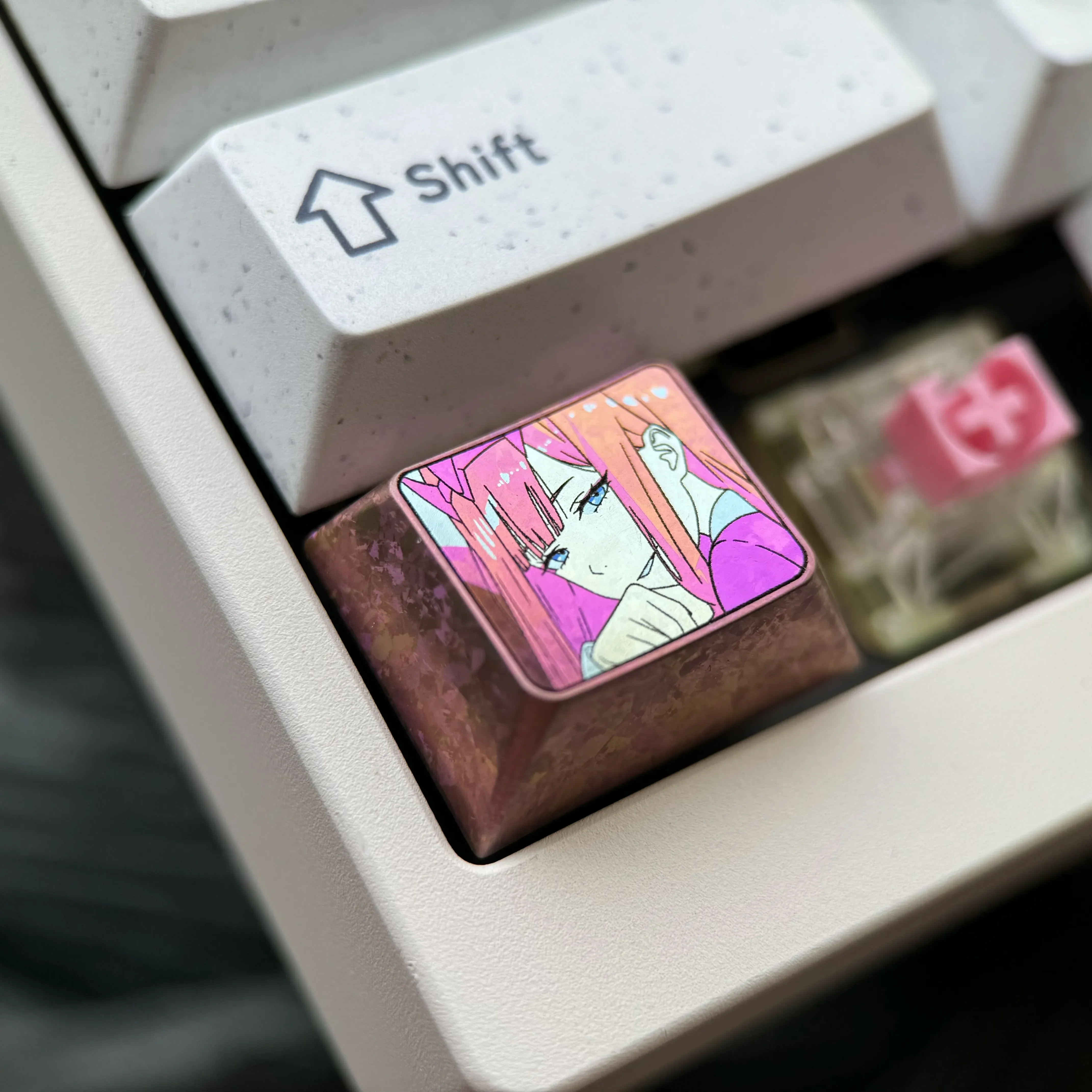 Vibrant Zero Two titanium keycap viewed from multiple angles, showcasing its durable polished alloy, iconic anime colors, and sleek custom design.