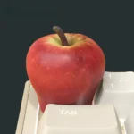 Various angles of the Peace Apple luminous resin artisan keycap, highlighting its rugged dark aesthetic and mystical red orb.