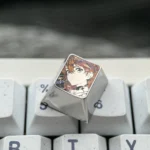 Close-up of the precision-carved Asuka ESC keycap, showcasing its intricate anime design and polished metallic finish from a side angle, a premium design.