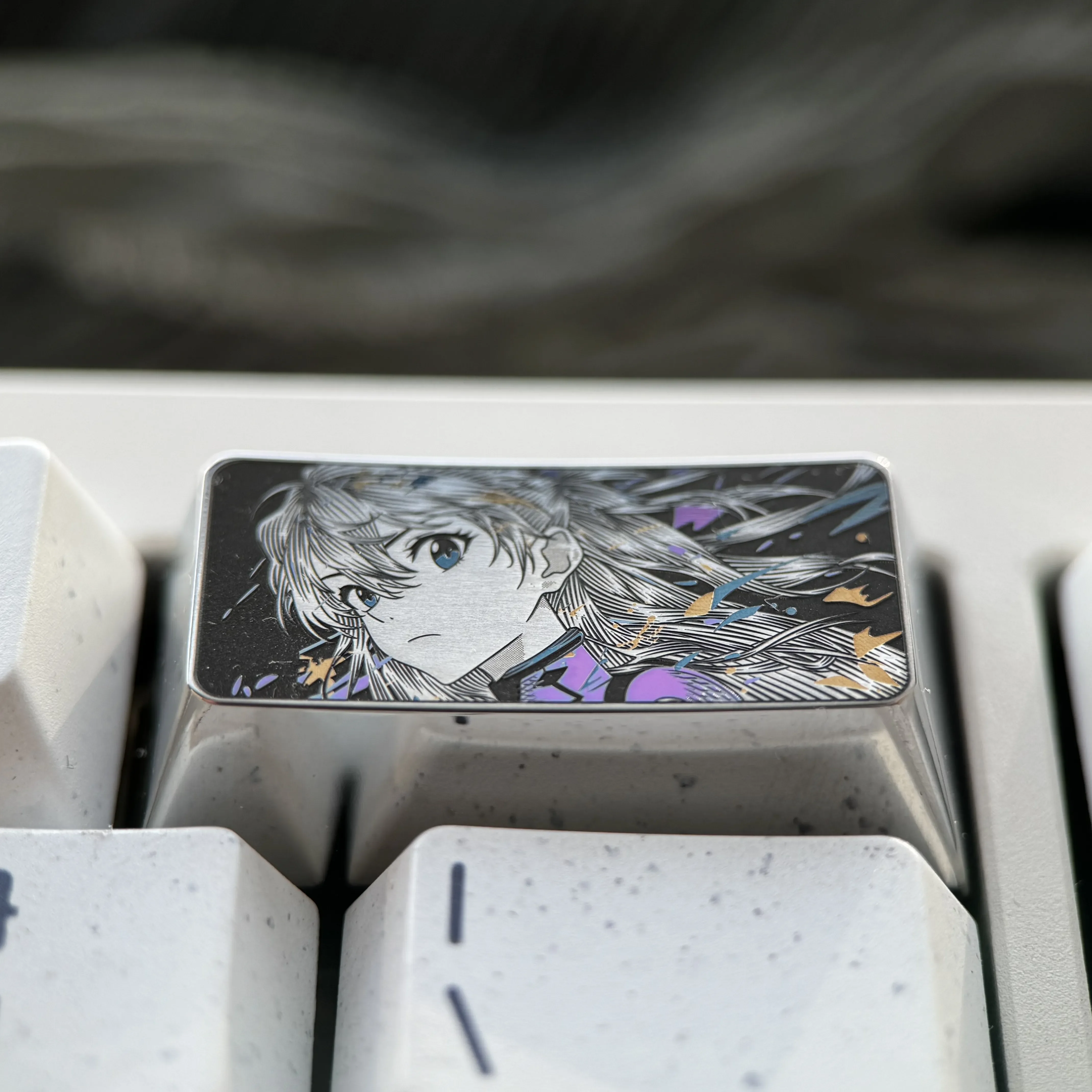 Close-up of the premium alloy Asuka keycap, meticulously showcasing the iconic Evangelion design and precision-engraved details.