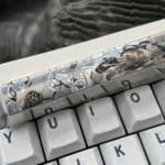 Close-up views of the precision-engraved Asuka Titanium Spacebar keycap, showcasing its vibrant anime mecha design and intricate details from multiple angles.