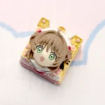 Handcrafted Cardcaptor Sakura resin keycap with vibrant Sakura Kinomoto figurine, showing magical girl details from diverse angles.
