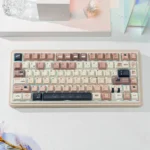 Whimsical Cat Keycap Set: Durable PBT dye-sub keycaps with charming feline art. Cozy coffee and cream palette, shown from multiple angles.